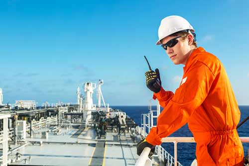 man in high visibility orange workwear talking on a walkie talkie