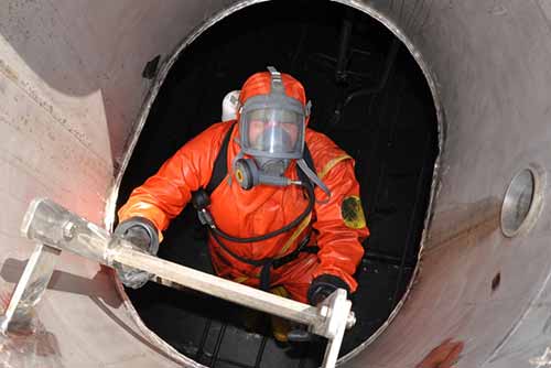 Worker wearing high visibility workwear wearing a gas mask