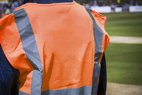 man in a high visibility orange vest at a sporting event