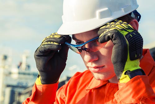 Man wearing ornage high visibility workwear with PPE