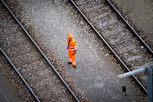 Rail worker in high visibility workwear standing working on the rail